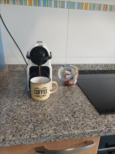 a cup of coffee sitting on a kitchen counter at HyP - Ático Forneira in Arcade