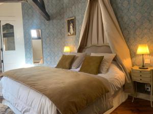 a bedroom with a large bed with a canopy at Chambres d'hôtes du château in Boulogne-sur-Mer