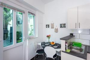 una cucina con tavolo, sedie e lavandino di Apartment Banjska a Dubrovnik