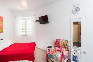 een slaapkamer met een bed, een bank en een stoel bij Apartment Banjska in Dubrovnik
