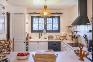 cocina con armarios blancos, fregadero y ventana en Chalet Soleil Blanc en Saint-Gervais-les-Bains