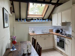 uma cozinha com uma mesa de madeira e um lavatório em Munden House em Sherborne