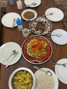 une table en bois avec des assiettes et des bols de nourriture dans l'établissement House Tanzania, à Moshi