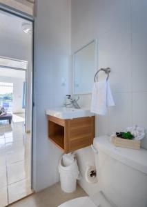 Baño blanco con lavabo y aseo en EDMA APARTAHOTEL, en Santa Bárbara de Samaná