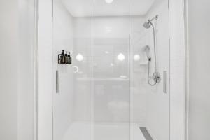 ein weißes Bad mit einer Dusche und einer Glastür in der Unterkunft Hotel Indigo Atlanta Vinings, an IHG Hotel in Atlanta