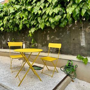 twee gele stoelen en een tafel en twee stoelen bij MONO Apartments Aldini in Bologna
