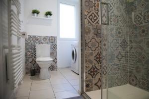 a bathroom with a toilet and a glass shower door at Gîte Le Tilleul - Calme et lumineux - 2 à 4 pers in Bessèges