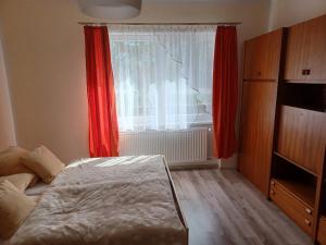 Radava 52 في Radava: غرفة نوم بسرير ونافذة ذات ستائر حمراء