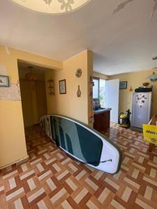 a surfboard sitting on the floor of a living room at Bungalow acogedor cerca a todo in San Bartolo