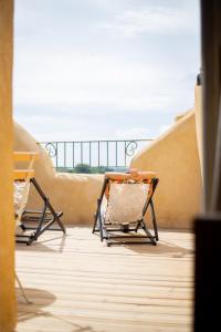 2 sillas en un balcón con vistas al océano en La Maison des Lamanon en Salon-de-Provence