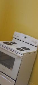 a white stove top oven sitting next to a yellow wall at Convenient with a view of downtown in Calumet