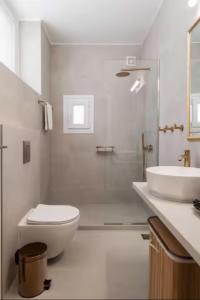 La salle de bains blanche est pourvue de toilettes et d'un lavabo. dans l'établissement Panathinea, à Athènes