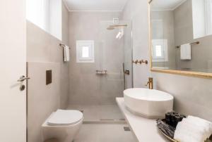 La salle de bains blanche est pourvue d'un lavabo et de toilettes. dans l'établissement Panathinea, à Athènes