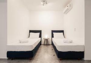 dos camas sentadas una al lado de la otra en una habitación en Panathinea en Athens
