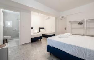 een slaapkamer met 2 bedden en een badkamer met een wastafel bij Panathinea in Athene