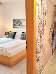 una camera da letto con un letto e un dipinto sul muro di Ferienpark Scheiber a Unterburg am Klopeiner See