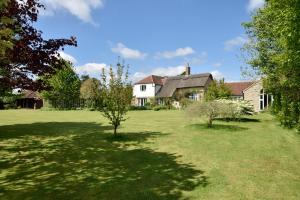 a large yard with a white house and trees at Munden House in Sherborne +24 photos