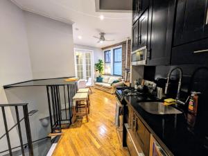 una cucina con armadi neri e piano di lavoro di Private Room at a shared Apartment at the Heart of East Village a New York