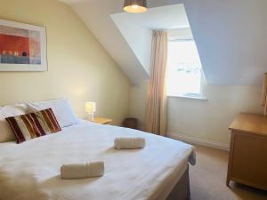 a bedroom with a white bed with two pillows on it at 3 bedroomed house with view of Kenmare Bay Estuary in Kenmare