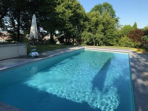 a swimming pool with blue water in a yard at Casa Rita, Charming House with pool, Asti in Asti