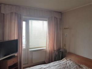 a bedroom with a bed and a television and a window at Lovely apartment in Riga city in Rīga
