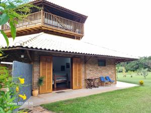 ein Haus mit einem Balkon, einem Tisch und Stühlen in der Unterkunft Recanto da Natureza in Brotas