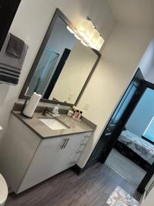 a bathroom with a sink and a large mirror at Downtown Augusta luxury 2bed apt in Augusta
