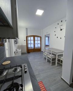 a kitchen with a stove and a table in it at Appartamento La Corte in Levico Terme