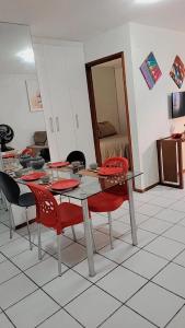 een eettafel met rode stoelen en een spiegel bij Apartamento Catamarã Port Ville Pajuçara Maceió in Maceió