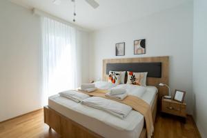 - une chambre avec un grand lit et des draps blancs dans l'établissement HM • Sunny 1BR Home with Balcony, à Vienne
