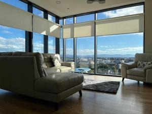 a living room with a couch and chairs and windows at The Western Citypoint Apartments in Galway