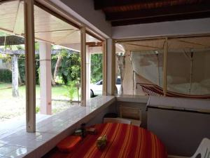 ein Esszimmer mit einem Tisch und einigen Fenstern in der Unterkunft Beautiful House in front of the beach at Masca, Omoa in Omoa