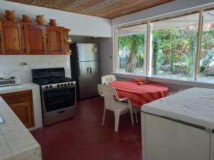 a kitchen with a table and a stove top oven at Beautiful House in front of the beach at Masca, Omoa in Omoa