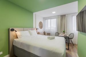 库里提巴Easy Life Campos PUC by Xtay - Conforto em Curitiba, a poucos minutos do Teatro Paiol e do Mercado Municipal的卧室里有一张白色的大床和一张书桌