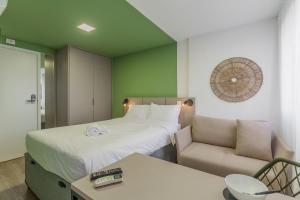 Easy Life Campos PUC by Xtay - Conforto em Curitiba, a poucos minutos do Teatro Paiol e do Mercado Municipal客房内的一张或多张床位