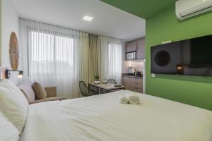 Easy Life Campos PUC by Xtay - Conforto em Curitiba, a poucos minutos do Teatro Paiol e do Mercado Municipal客房内的一张或多张床位