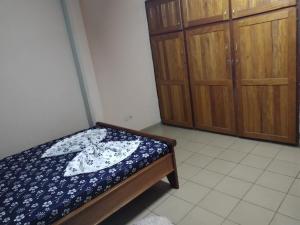 雅溫德的住宿－Appartement biteng，一间卧室配有一张床和一些木橱柜。