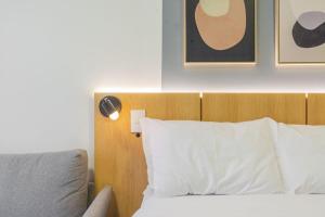 Easy Life Campos PUC by Xtay - Conforto em Curitiba, a poucos minutos do Teatro Paiol e do Mercado Municipal客房内的一张或多张床位
