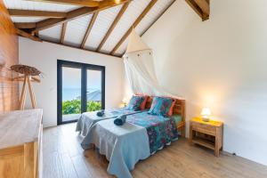 a bedroom with a bed and a large window at Calypso Bay in Bouillante