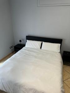 a large white bed with two pillows on it at b&b 17 in Maddaloni
