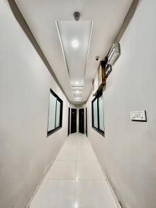 a corridor in a room with white walls and windows at Hotel Evanka in Indore