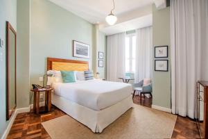 a bedroom with a large white bed and a chair at Fera Palace Hotel in Salvador