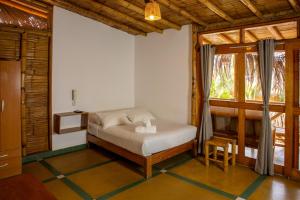 a bedroom with a bed in a room with a window at El Mirador de Vichayito in Vichayito