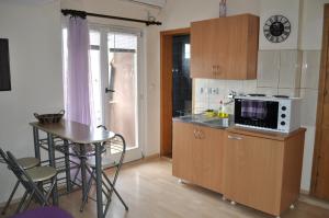 a small kitchen with a table and a microwave at Apartmani Bon Bons in Soko Banja