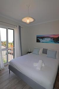 una camera da letto con un grande letto bianco e una finestra di Laura's House a Santa Cruz