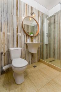 uma casa de banho com um WC, um lavatório e um espelho. em Curaçao Apartments - Building Stefan em Mamaia Nord – Năvodari