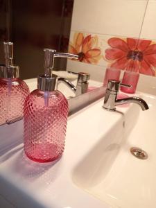 un lavandino in bagno con dispenser di sapone rosso di GiuattyHomeHoliday Termoli a Termoli