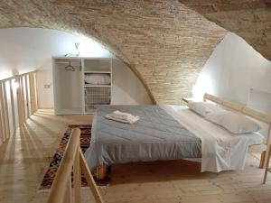 sypialnia z łóżkiem i ceglaną ścianą w obiekcie GiuattyHomeHoliday Termoli w mieście Termoli