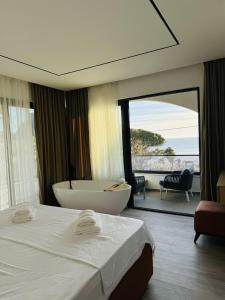 a hotel room with a bath tub and a bedroom at Botanica Boutique Hotel in Ulcinj