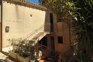 un bâtiment avec un escalier sur son côté dans l'établissement Le Chiavi, à Erice